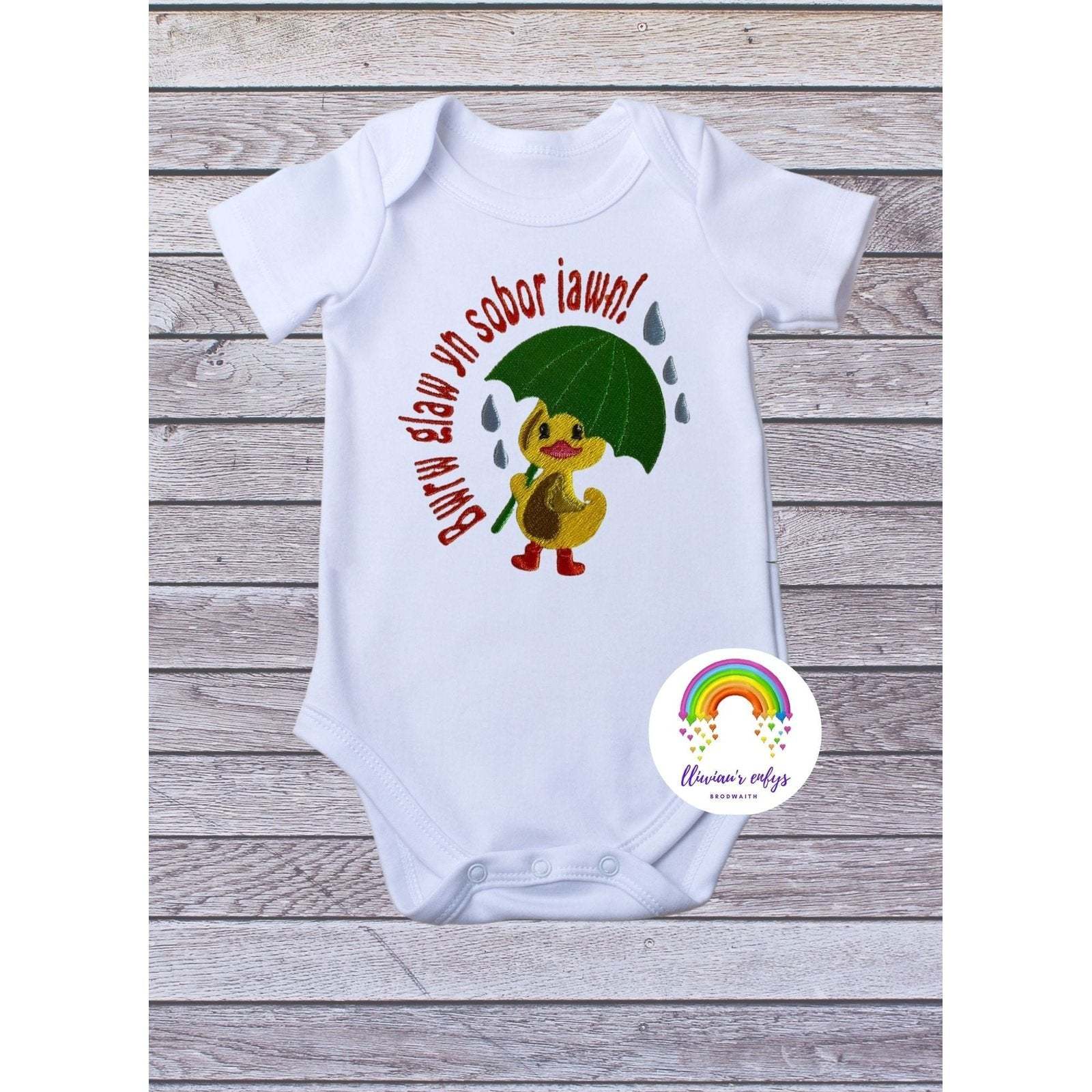 BRO-003 Newborn embroidered babygrow with Welsh words "Bwrw glaw yn sobor iawn"