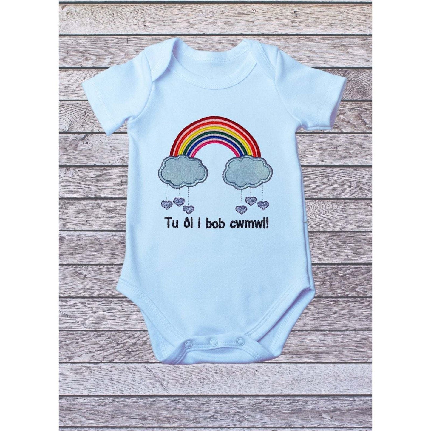 BRO-009 Embroidered rainbow babygrow with Welsh text "Tu ôl i bob cwmwl"