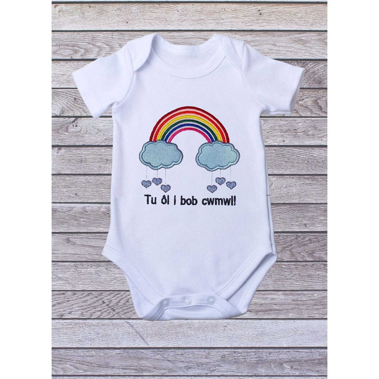 BRO-009 Embroidered rainbow babygrow with Welsh text "Tu ôl i bob cwmwl"